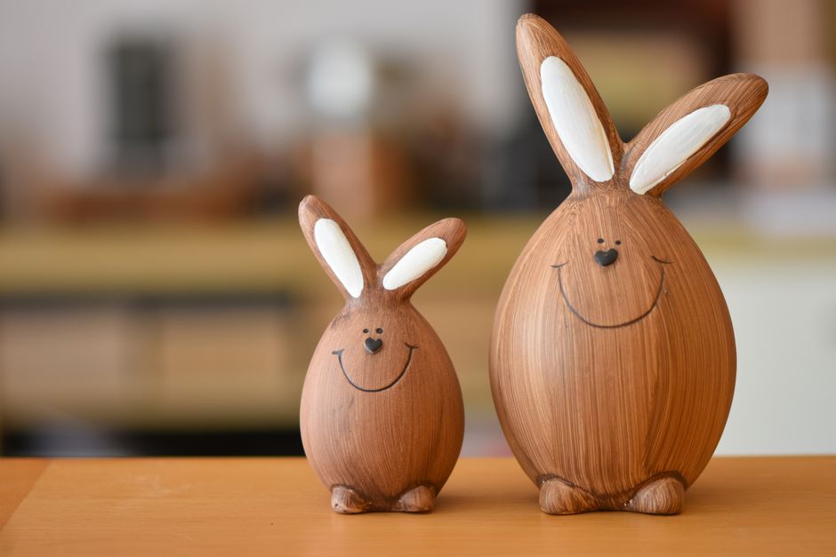 Smiling wooden bunny figures in a warm indoor setting. Perfect for Easter decor.