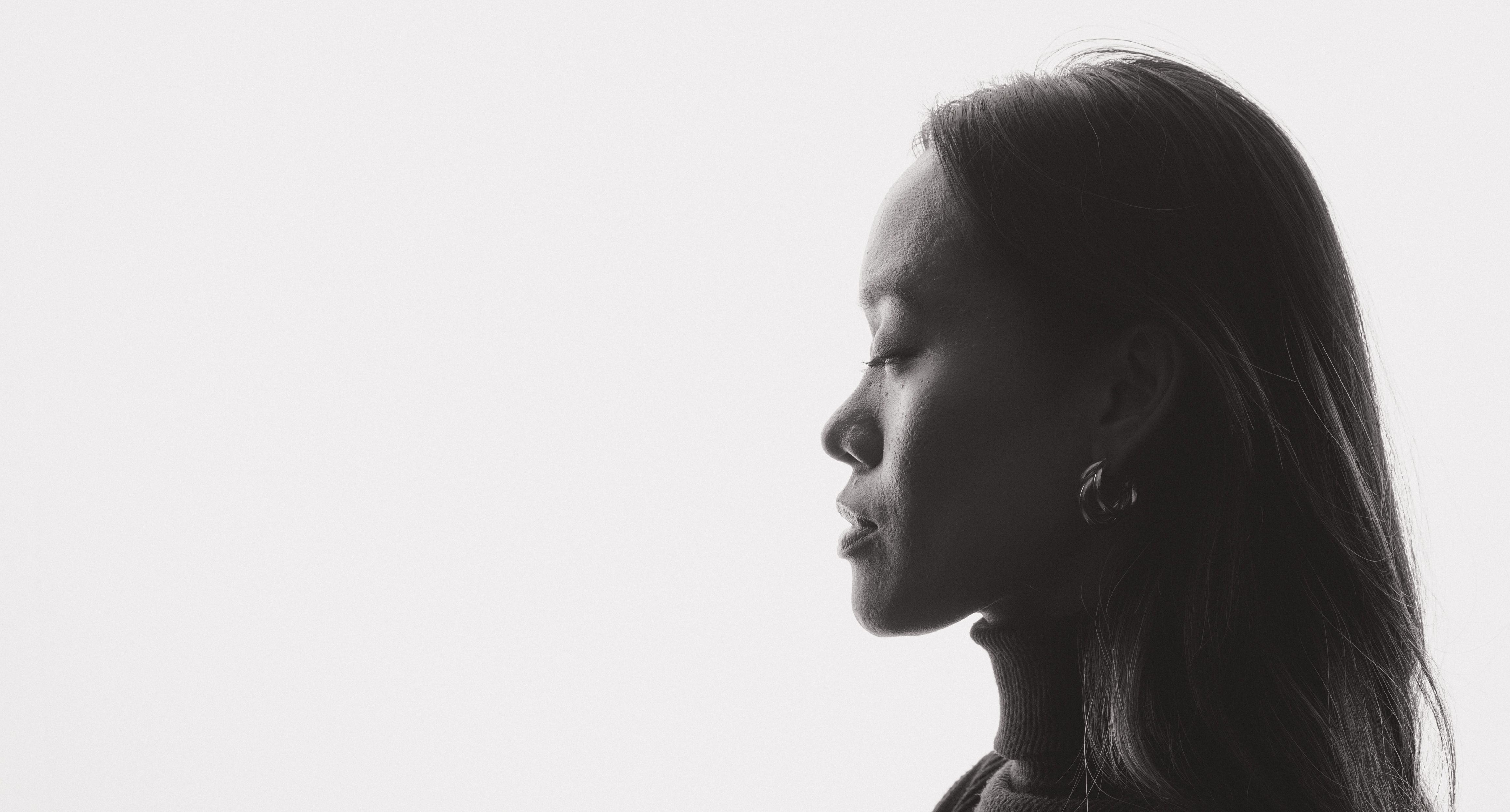 Elegant black and white profile portrait of a woman with closed eyes in a serene pose.