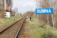 Railroad tracks leading to Šumná station surrounded by spring foliage.