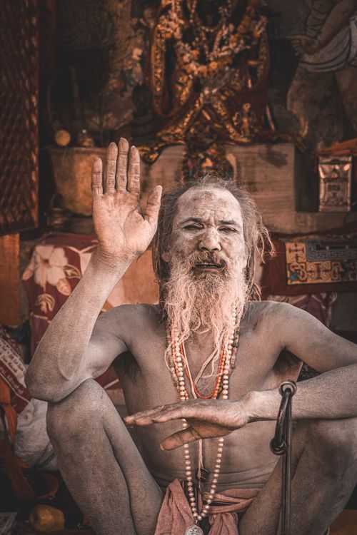 Free A peaceful image of an Indian sadhu meditating, raising a hand in gesture, in traditional attire. Stock Photo