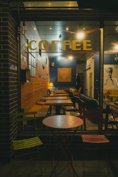 Inviting coffee shop window view with warm interior lighting at night in Houston, Texas.