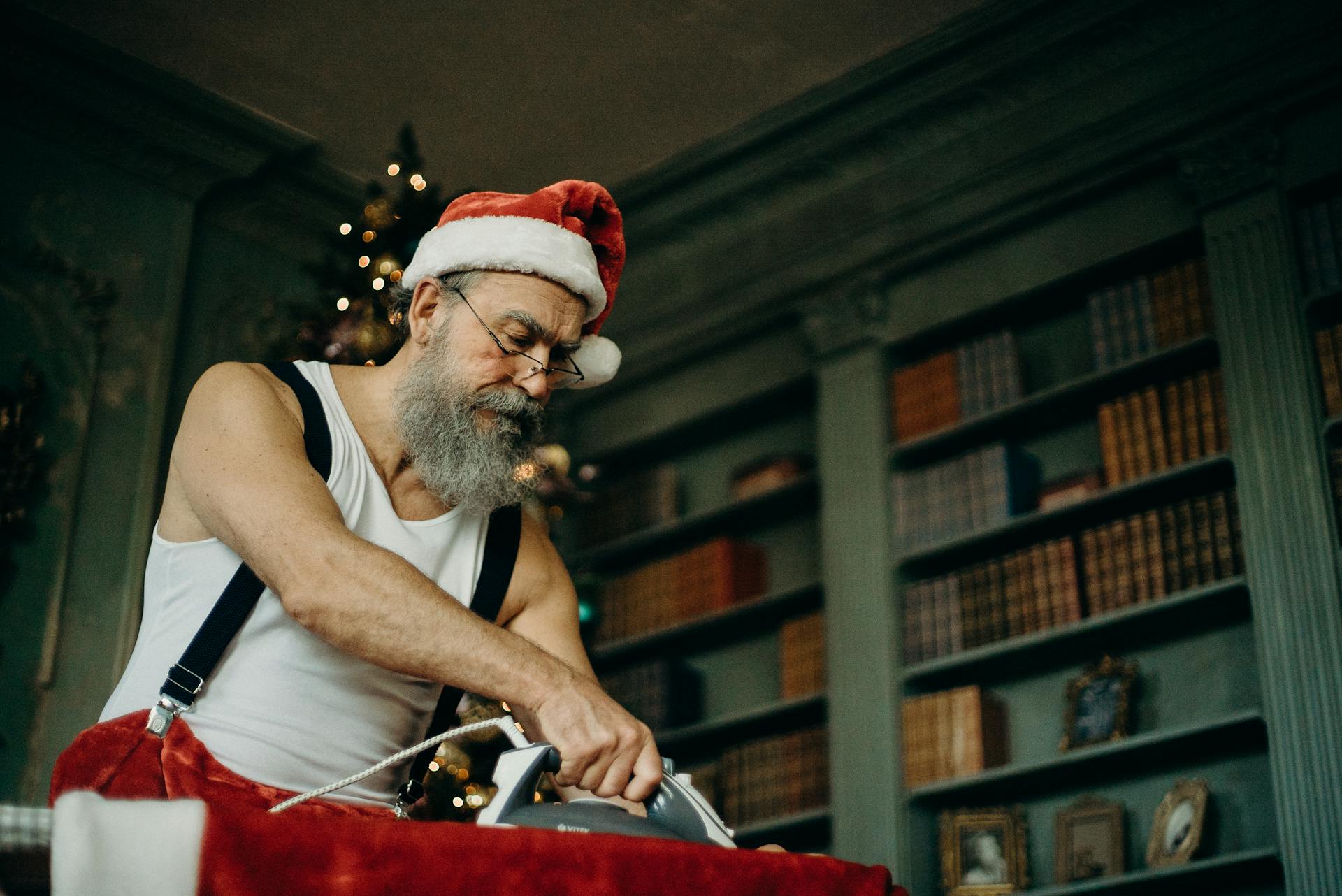 Man Wearing Santa Claus Costume Ironing Cloth