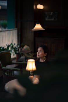 昏暗的老式咖啡馆里，温暖的灯光映照着一个女人的艺术肖像