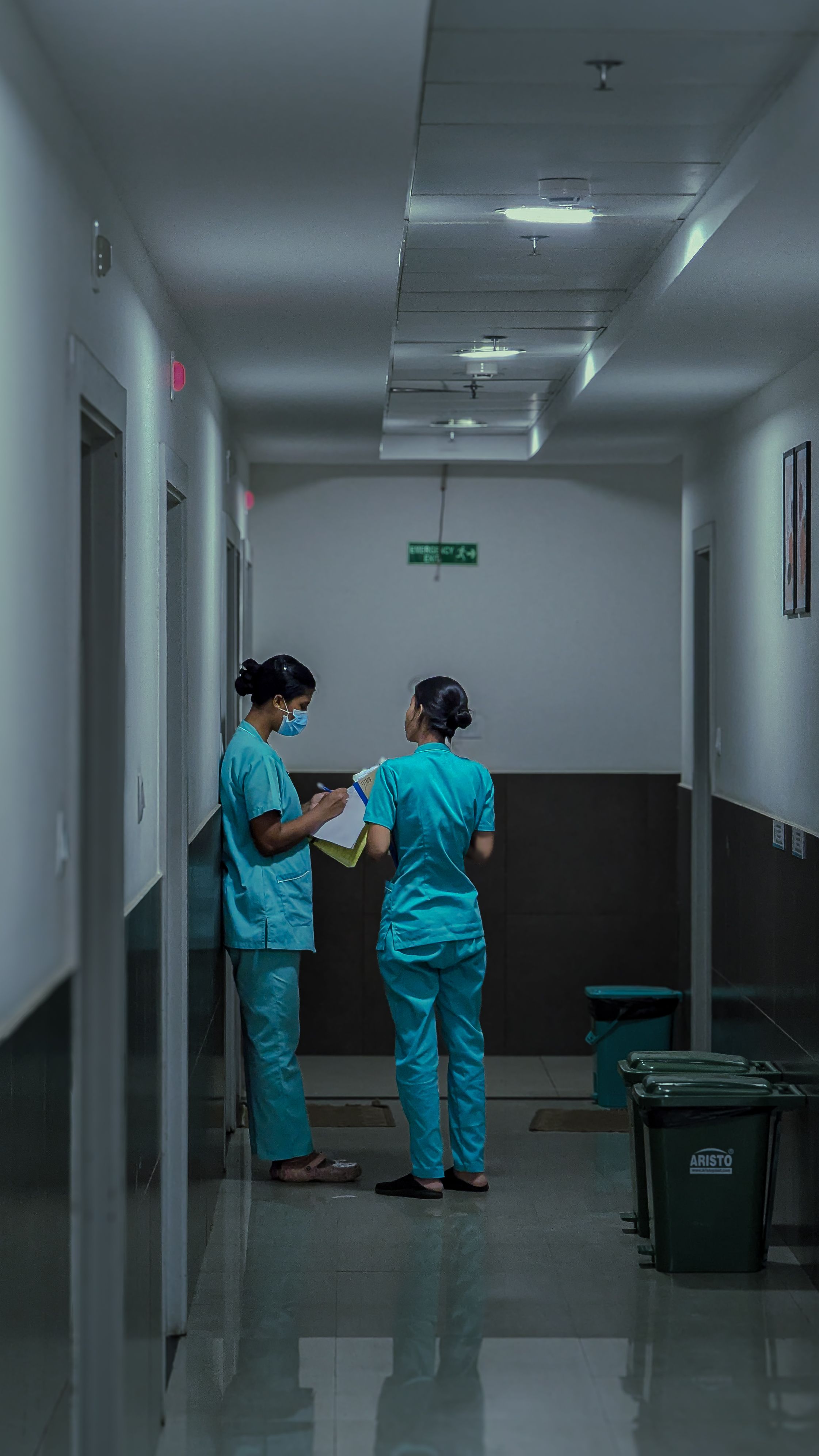 Nurses reviewing patient notes in a hospital corridor