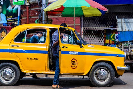 A vibrant yellow taxi on a bustling street in Kolkata, showcasing local life and culture.