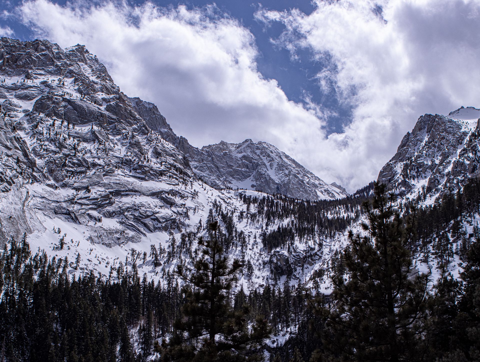 A stunning view of the snow-capped Sierra Nevada mountains under a cloudy sky.
