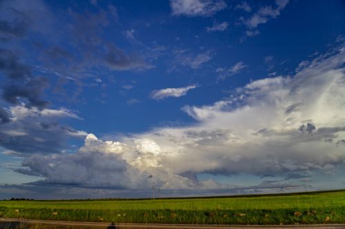 Free Expansive clouds and vibrant green fields under a deep blue sky in KwaZulu-Natal, South Africa. Stock Photo