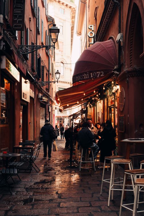 Free Cozy street cafe in Bologna during a busy day, capturing the essence of Italian street life. Stock Photo
