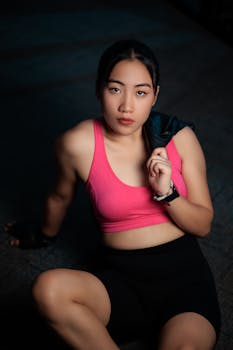 A young woman in sportswear takes a break after a workout, exuding strength and determination.