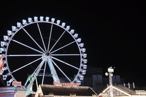 Free Brightly lit Ferris wheel at night in Hamburg, showcasing city lights against a dark sky. Stock Photo