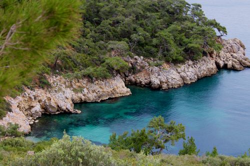 Free Stunning view of a rocky cove with turquoise waters and lush greenery in İzmir, Türkiye. Stock Photo