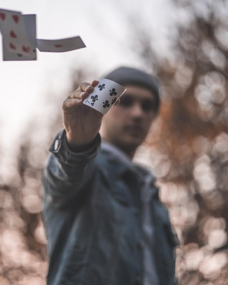 Burred Photo Of A Man Holding Ace Playing Card