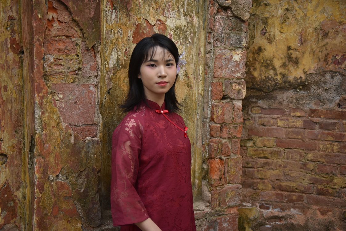 Beautiful Woman in Red Dress Standing by Rustic Wall · Free Stock Photo