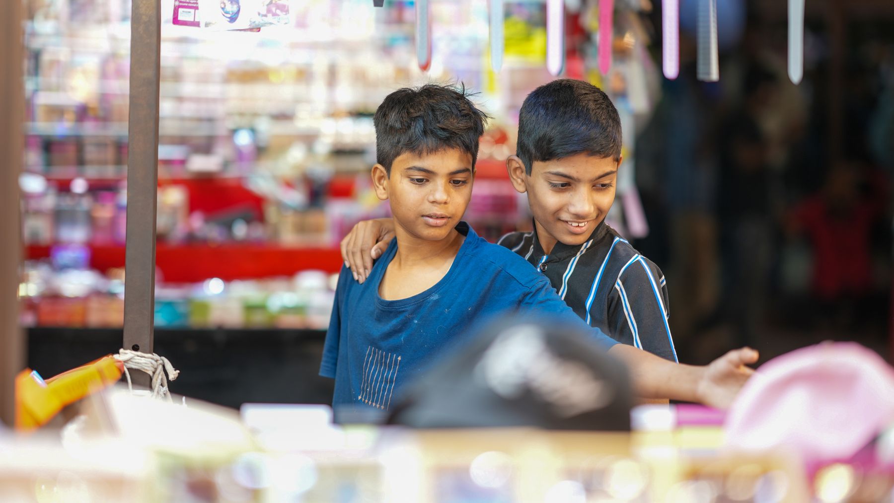 Children browsing products at a local market stall, representing the moment a business meets a real customer