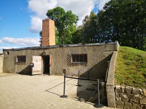 Free Old stone building with a chimney surrounded by trees, depicted on a sunny day. Stock Photo