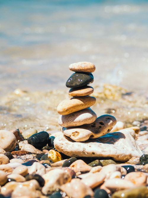 Free Serene rock stack on sunny beach symbolizes balance and harmony. Stock Photo