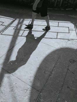 黑白图像极简地捕捉了人行道上行走之人的阴影