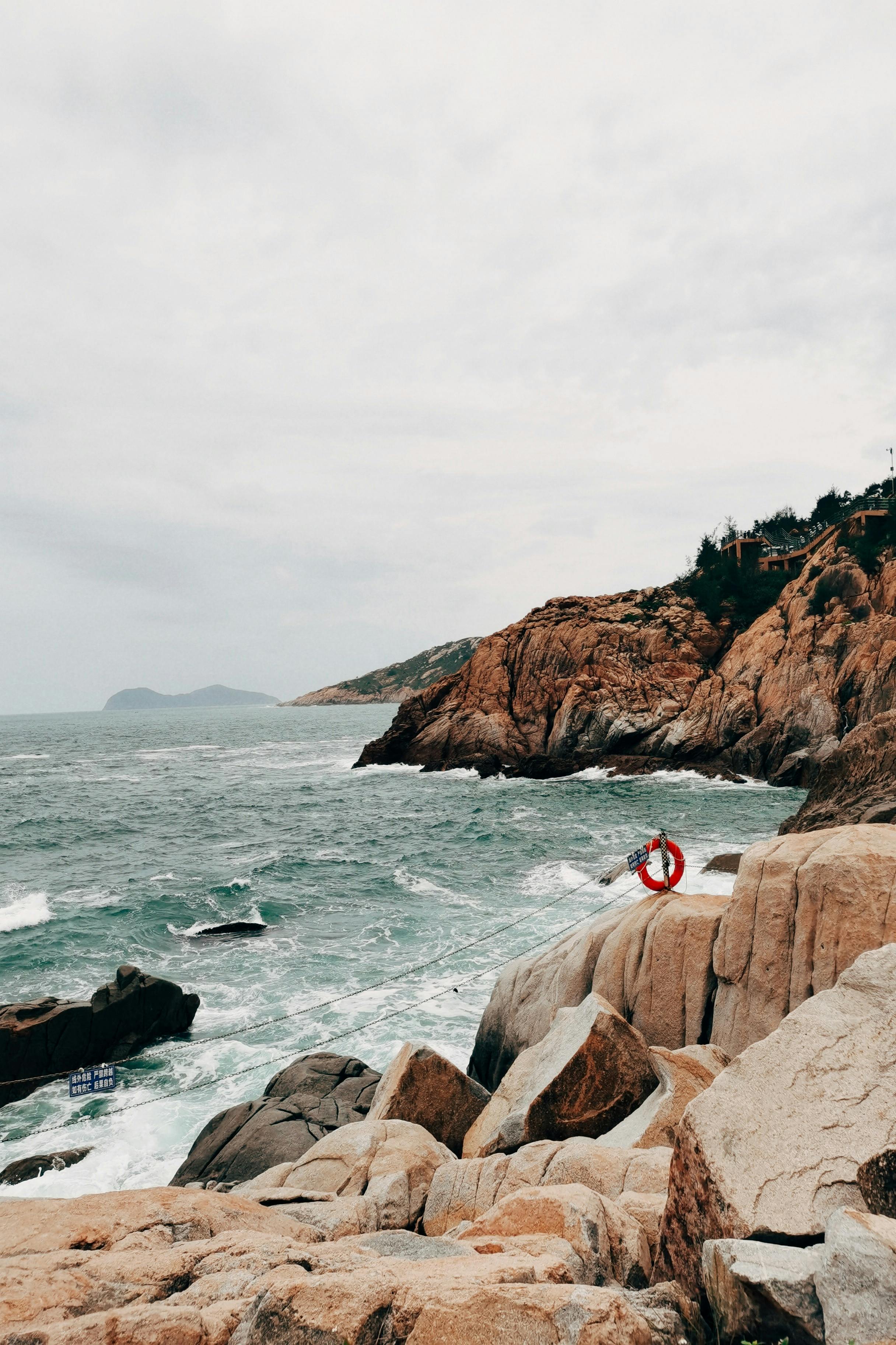 Dramatic rocky coastline with ocean waves in China, perfect for travel and nature themes.