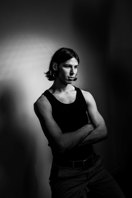 Free Black and white portrait of a young man in deep thought, arms crossed. Stock Photo