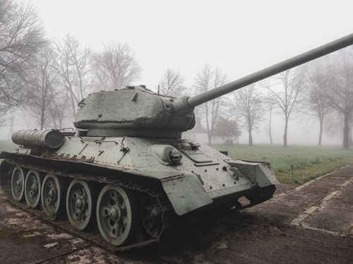 Free Soviet T-34 tank displayed outdoors on a foggy winter morning surrounded by trees. Stock Photo