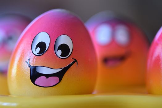 Vibrant, smiling Easter eggs with cartoon faces painted, perfect for festive celebrations.