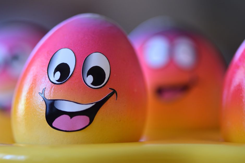 Vibrant, smiling Easter eggs with cartoon faces painted, perfect for festive celebrations.