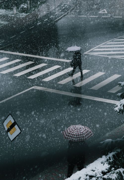 Free A snowy day in the city as people cross a wet street with umbrellas, creating a moody urban scene. Stock Photo