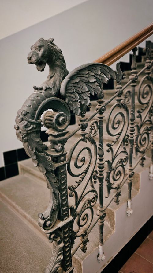 Free Intricate Gothic-style spiral staircase with dragon and floral details. Stock Photo