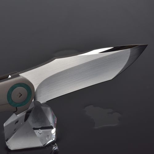 Free Elegant knife with shiny metallic blade on a reflective crystal base against dark background. Stock Photo