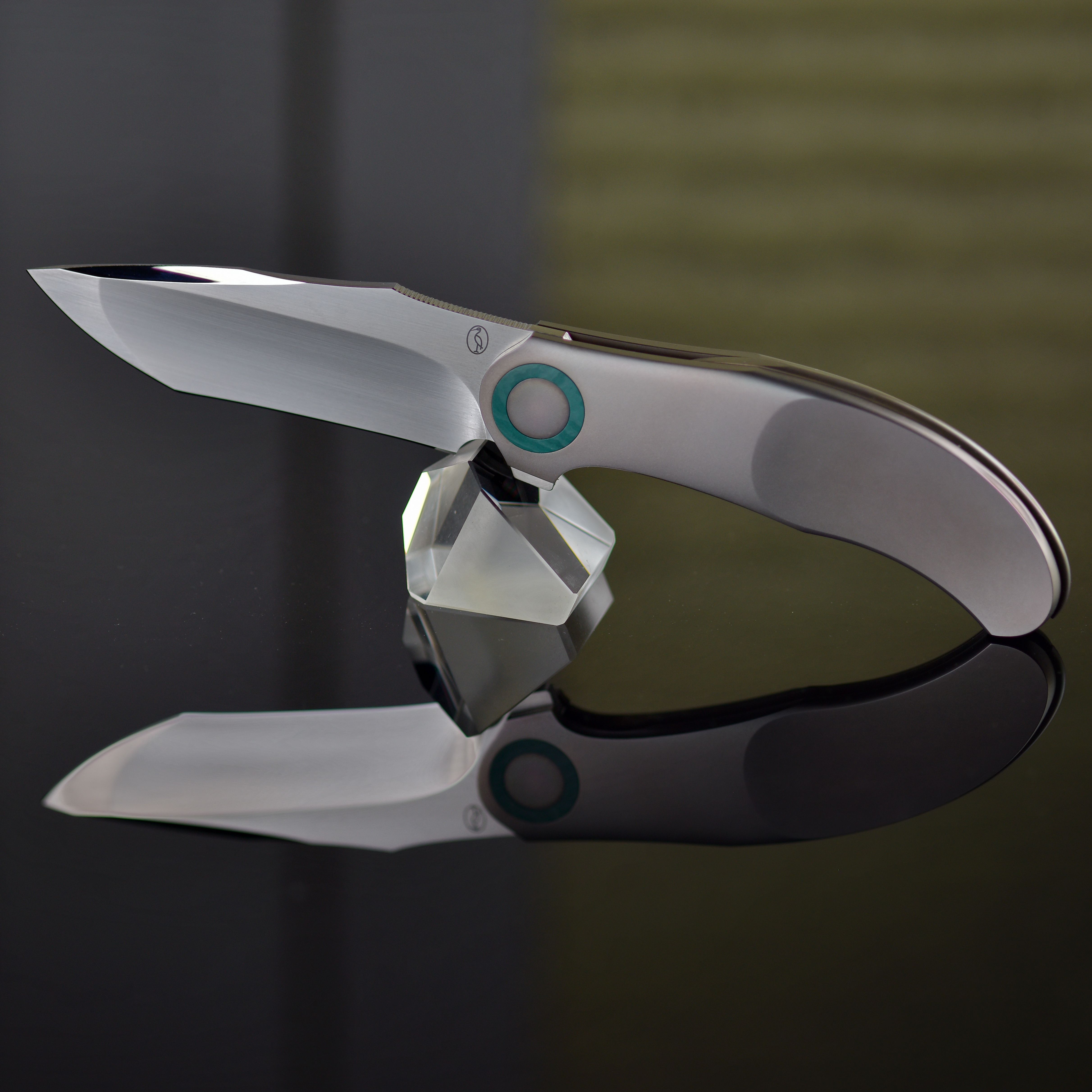 Modern stainless steel knife gracefully displayed on a reflective surface, highlighting its sleek design.