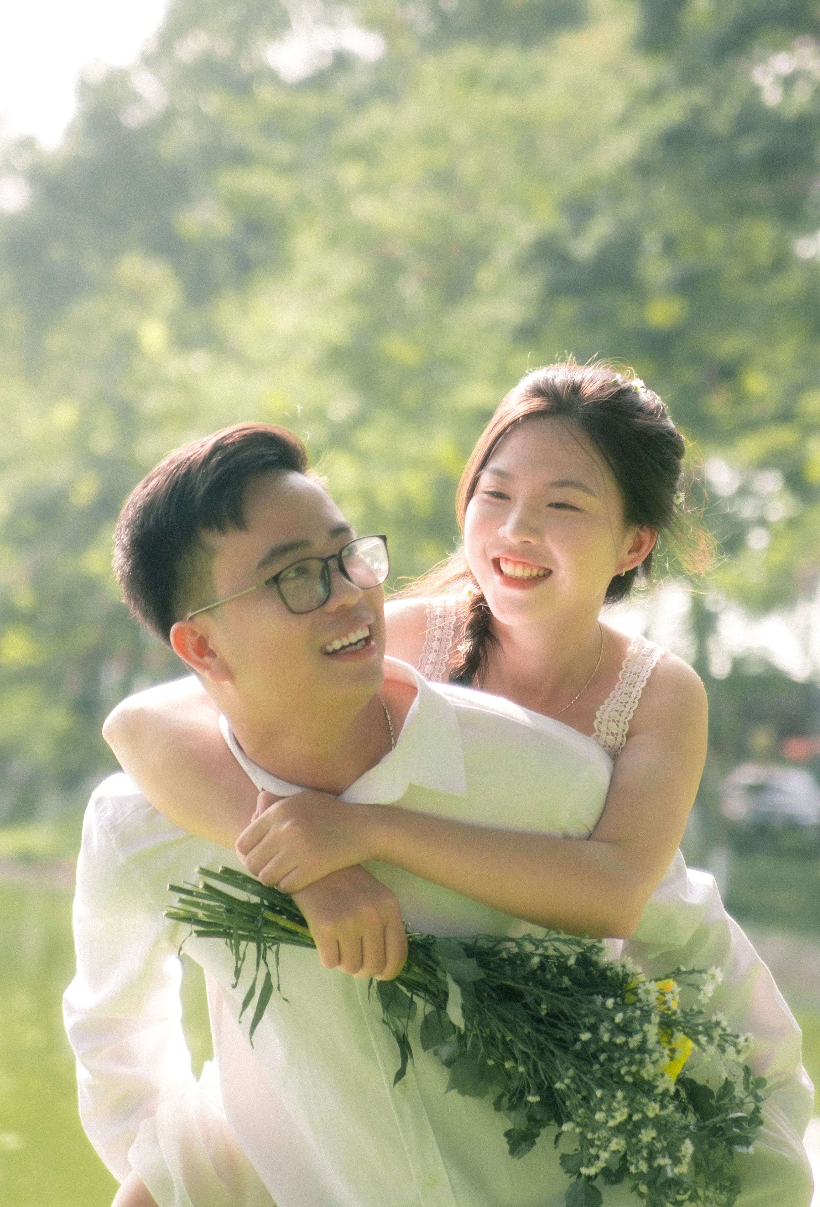 Joyful Couple Piggyback in Sunlit Park · Free Stock Photo