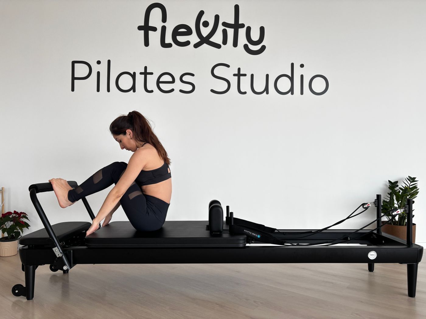 A participant practising Pilates on a reformer machine