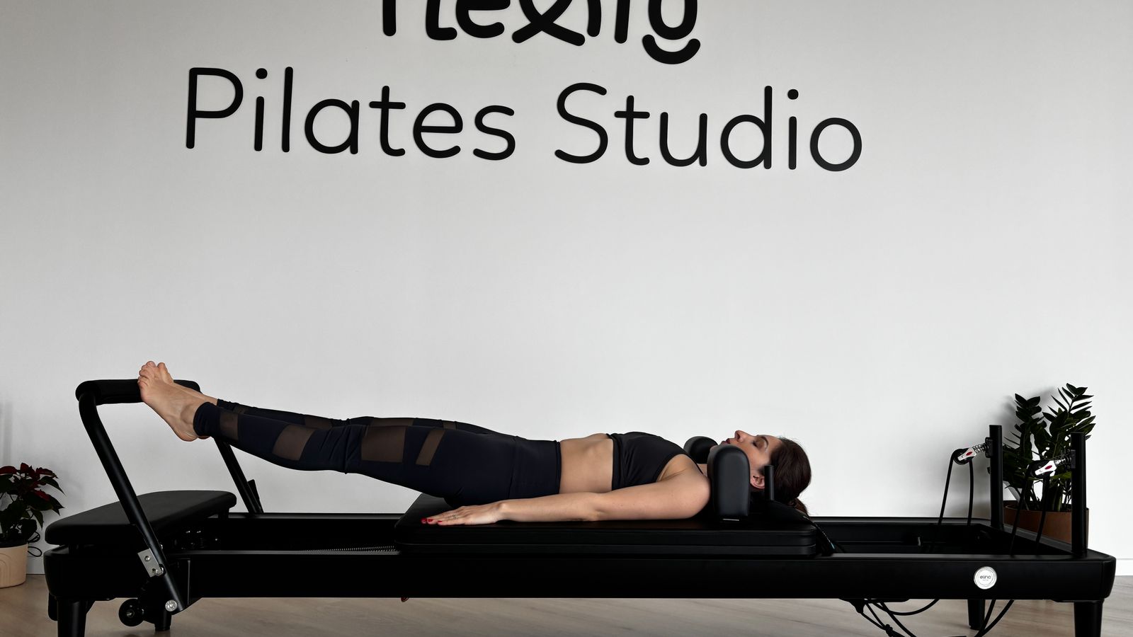 Exercício de pilates numa máquina reformer.