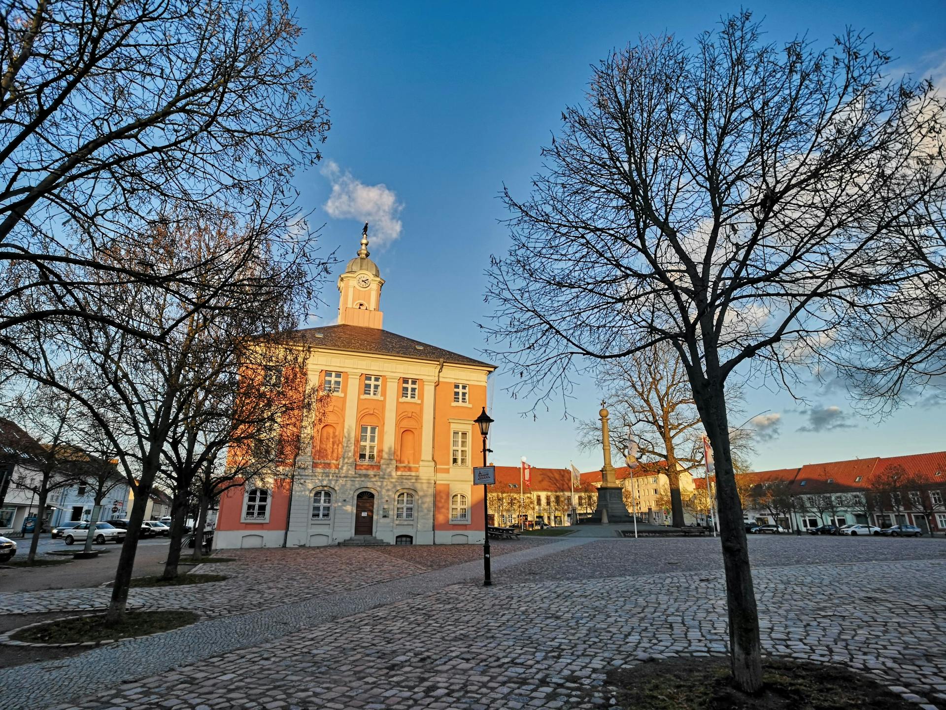 Beautiful medieval architecture in a sunlit German town square with cobblestones and winter trees.