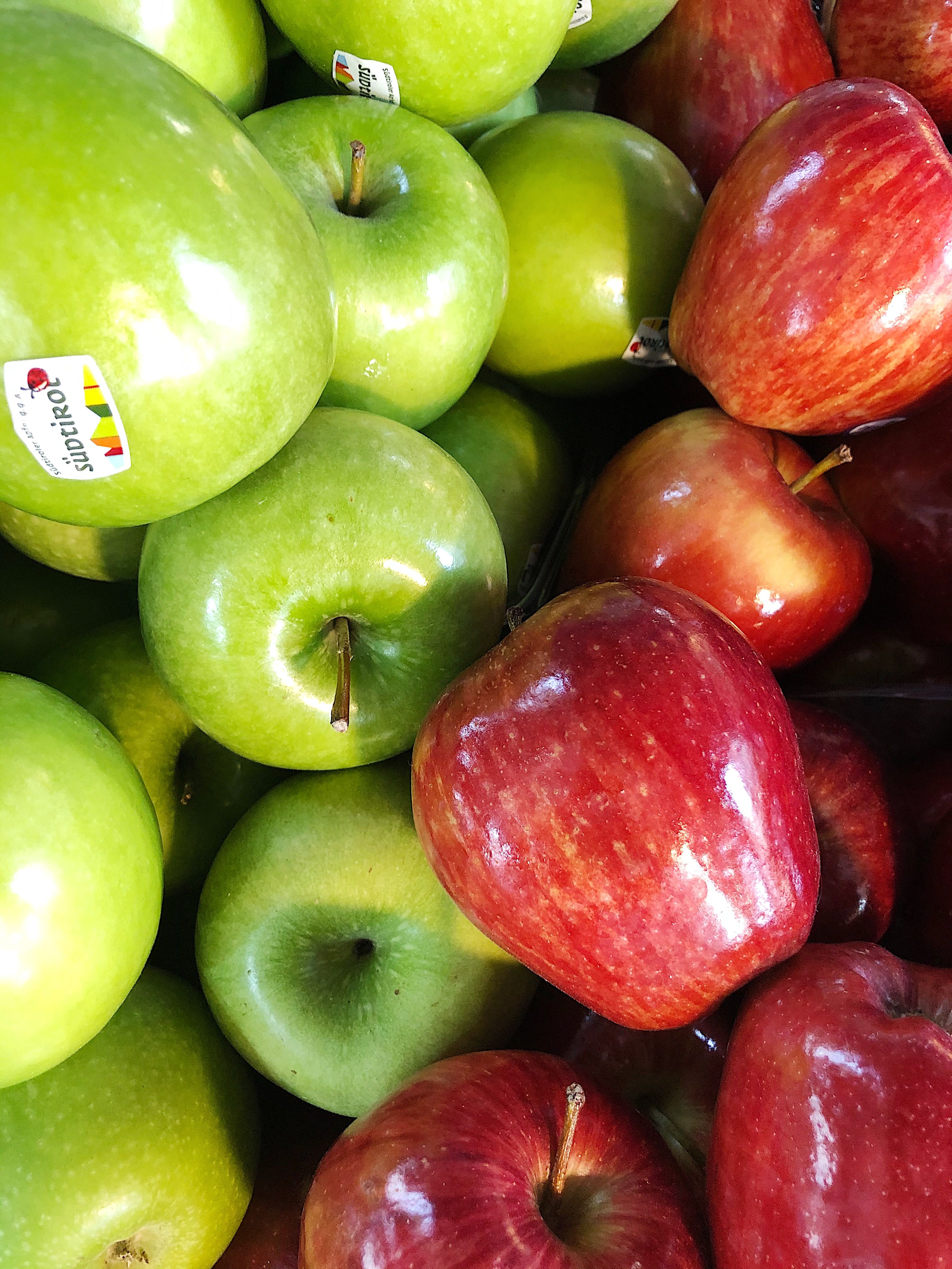 A vibrant assortment of red and green apples stacked in a market setting, showcasing freshness.