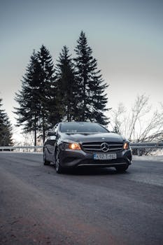 A sleek Mercedes-Benz car parked on a forest road in Ilidža, Bosnia. Captured in a cinematic style.