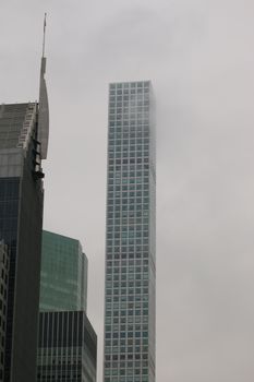 Tall skyscraper on Park Avenue reaching into the foggy New York City skyline.