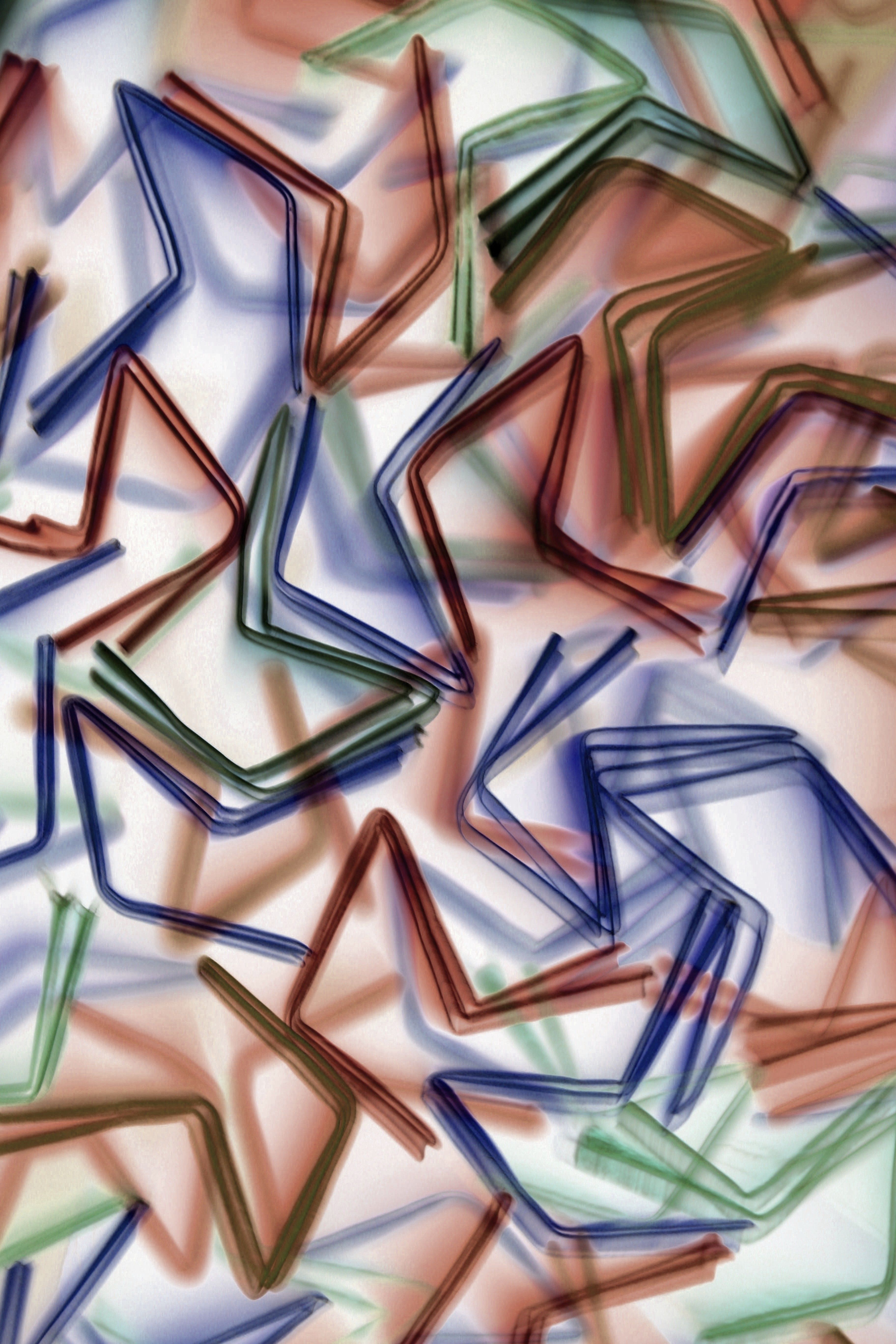 A vibrant abstract pattern of bent colored straws in blue, green, and red hues, creating a dynamic and artistic visual.