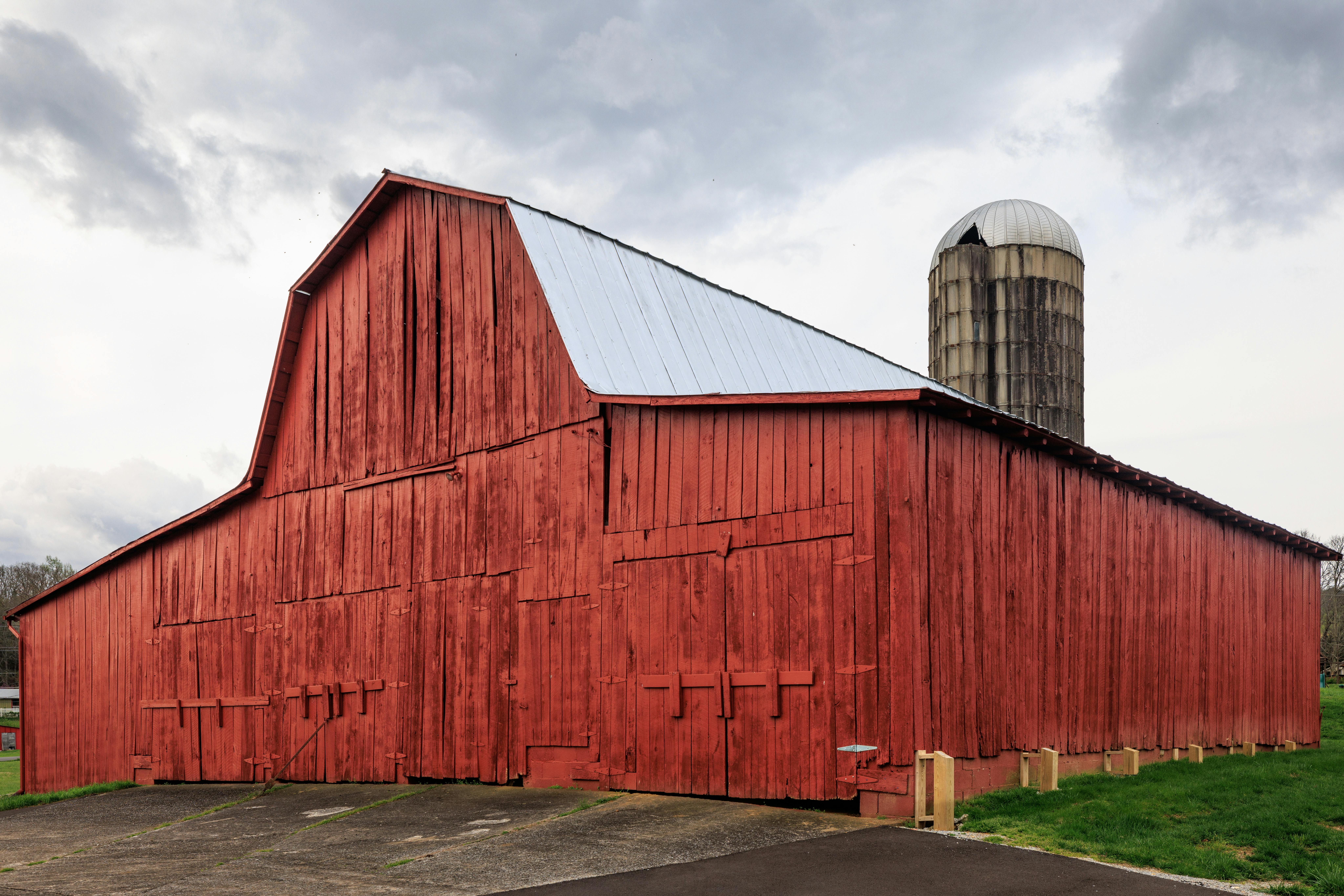 Nashville Wedding DJs: Where Country Meets Celebration - Charming red barn and silo set against a cloudy sky in Wears Valley, Tennessee.