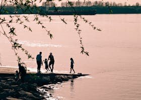 A family enjoys a serene sunset at the Yangtze River in Nanjing, China.