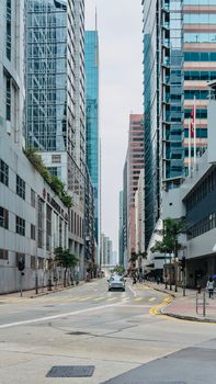 View of a modern urban street flanked by high-rise buildings in downtown Hong Kong.