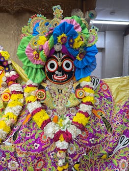 A colorful and intricate depiction of the Jagannath deity adorned with vibrant flowers and traditional attire.
