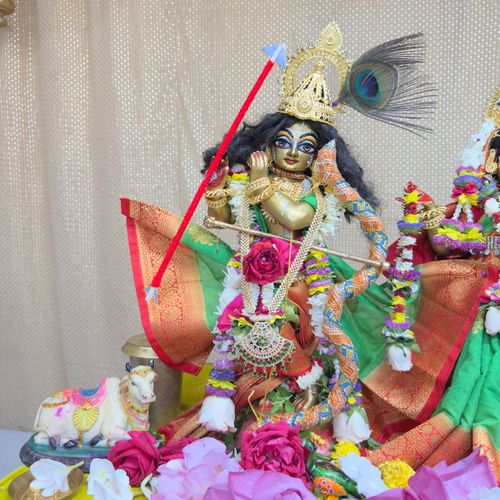 Free Vibrant sculpture of a Hindu deity adorned with flowers and ornaments, representing cultural richness. Stock Photo