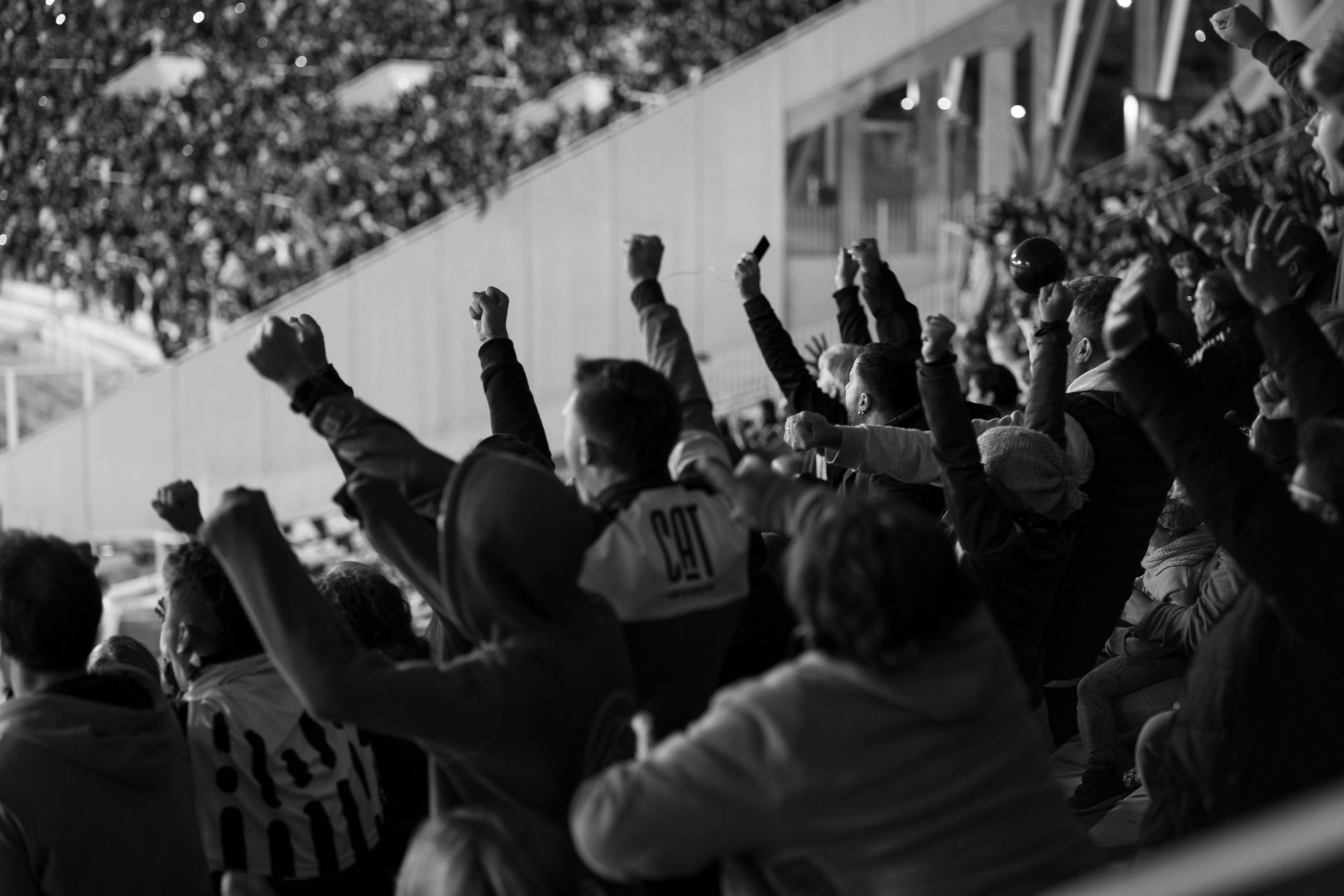 Tribunas llenas de un estadio de fútbol durante un partido nocturno