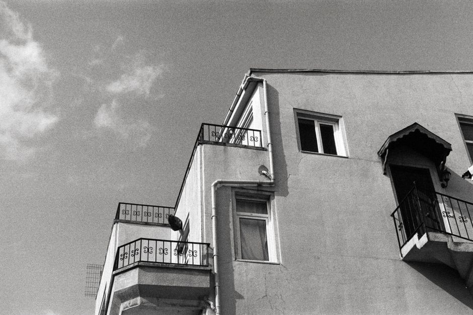 Monochrome photo of a building in Istanbul with a cat on the balcony, capturing urban aesthetics.