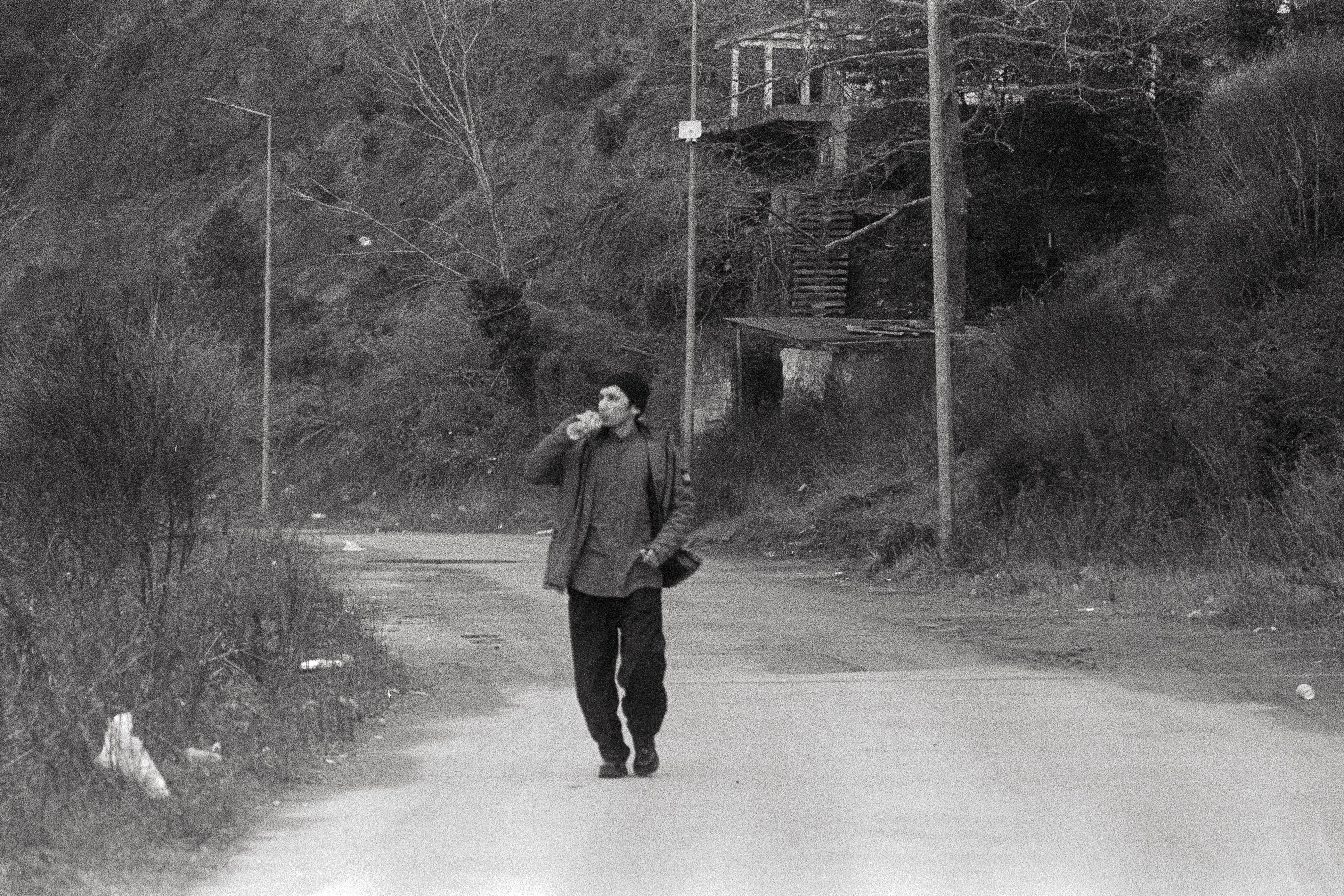 Black and White Portrait of a Man Walking Outdoors · Free Stock Photo