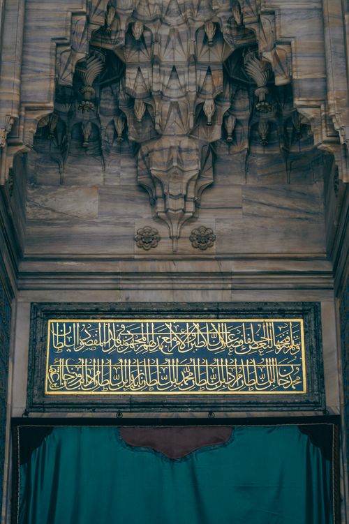 Free Exquisite Arabic calligraphy adorns a marble archway, showcasing intricate design and cultural artistry. Stock Photo