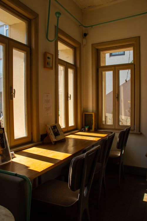 Free Inviting indoor workspace with sunlight streaming through large windows, ideal for focused work or studying. Stock Photo