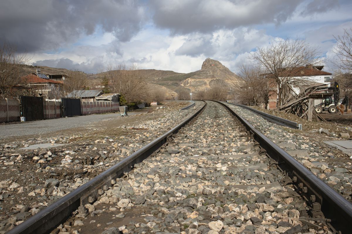 heavy railway tracks running toward mountain horizon