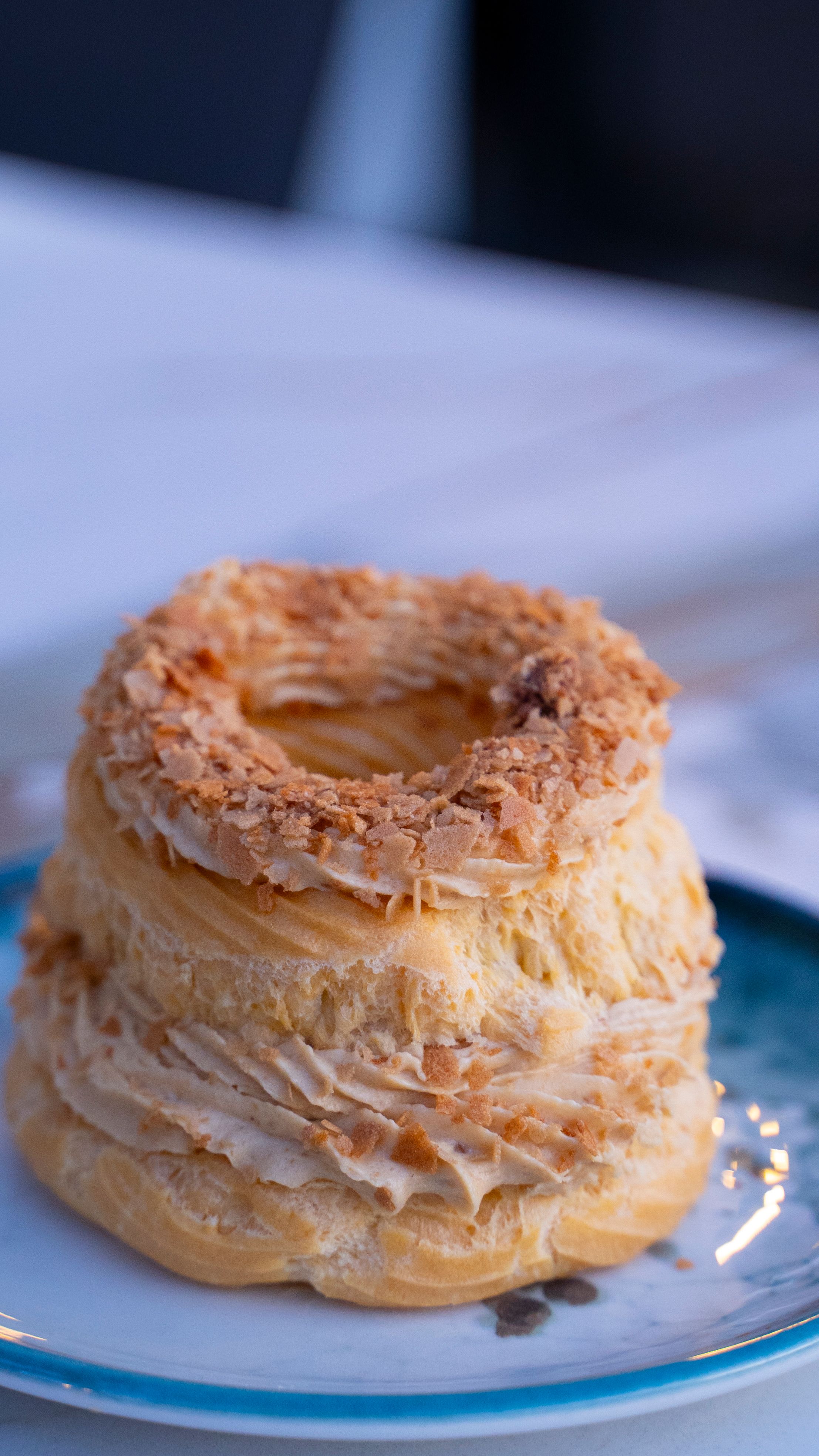 Photo of a Turkish dessert pastry, flaky and layered, on a blue plate.